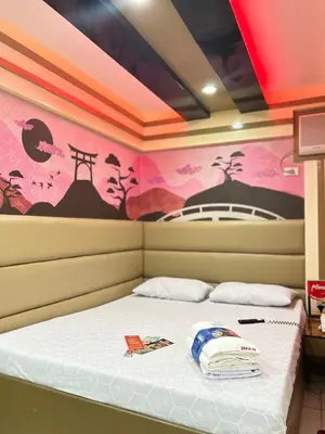 a bed in a room with a painting on the wall at Hotel Sogo Molino in Cavite