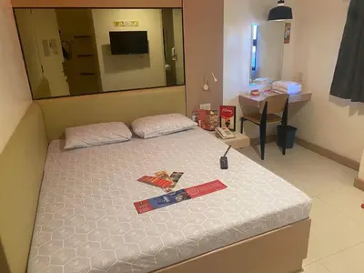 a bedroom with a bed with a large mirror and sidx sidx sidx at Hotel Sogo San Pedro in San Pedro