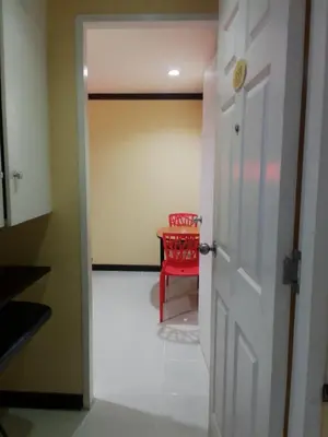 a hallway with a red chair and a table at Hotel Sogo San Pedro in San Pedro