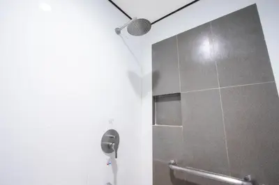 a bathroom with a shower stall with a microphone at Hotel Sogo Santolan in Manila