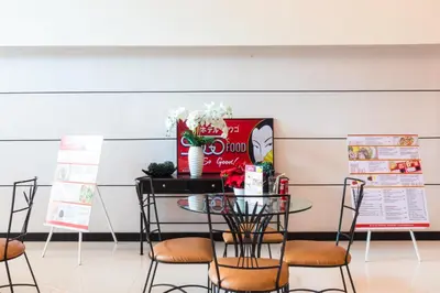 a table and chairs in a room with signs at Hotel Sogo Santolan in Manila