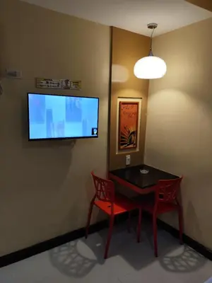 a dining room with a table and two chairs and a flat screen tv at Hotel Sogo Recto in Manila