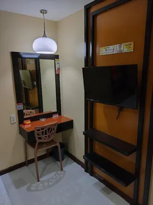 a room with a tv and a table and a mirror at Hotel Sogo Recto in Manila