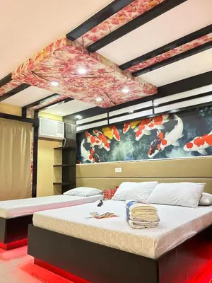 a bedroom with two beds and a painting on the wall at Hotel Sogo Sta Rosa in Santa Rosa