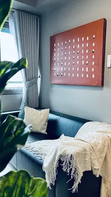 a bedroom with a couch and a plant and a window at WinTer Home Stay at S Residences Near Mall of Asia in Manila