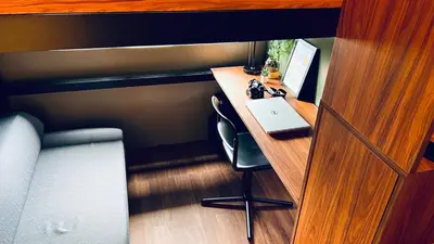 a room with a desk with a laptop computer on it at WinTer Home Stay at S Residences Near Mall of Asia in Manila