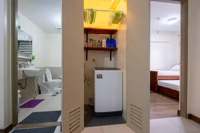 a bathroom with a small refrigerator in a room with a bed at 2BR Fully Air-Conditioned Staycation PLUS Free Parking in Manila