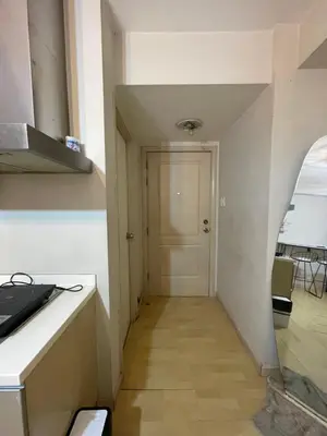 a hallway leading to a kitchen with a door at SOHO Central EDSA Shaw Condo Pool front with SMART TV in Manila