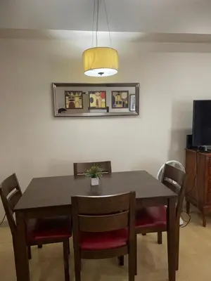 a dining room table with chairs and a lamp at SOHO Condotel EDSA Shaw near SM Megamall FREE Pool Access in Manila