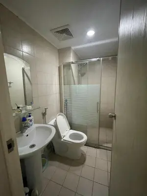 a bathroom with a toilet and a sink and a shower at SOHO Condotel EDSA Shaw near SM Megamall FREE Pool Access in Manila