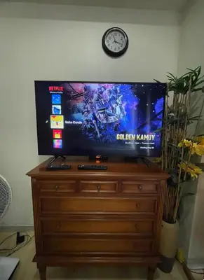a television on top of a wooden dresser with a clock at SOHO Condotel EDSA Shaw near SM Megamall FREE Pool Access in Manila