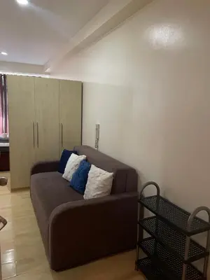 a living room with a brown couch in a room at SOHO Condotel EDSA Shaw near SM Megamall FREE Pool Access in Manila