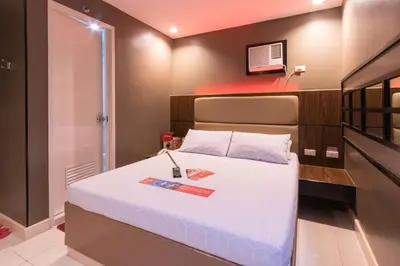 a bedroom with a bed and a tv on the wall at Hotel Sogo Santa Mesa in Manila