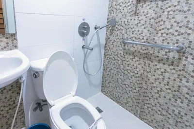 a bathroom with a shower and a toilet and a sink at Hotel Sogo Santa Mesa in Manila