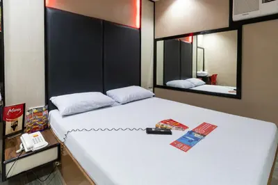 a bedroom with a large white bed with two mirrors at Hotel Sogo Santa Mesa in Manila