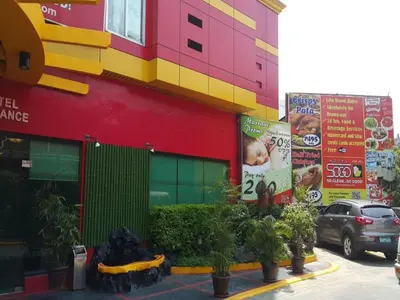 a colorful building with plants in front of it at Hotel Sogo Santa Mesa in Manila