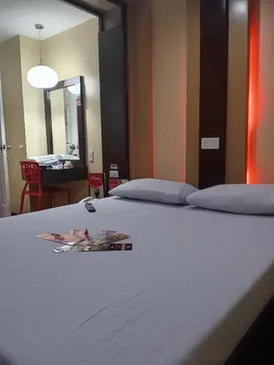 a bed with two pillows on it with a mirror at Hotel Sogo Edsa Taft in Manila