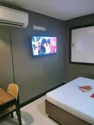 a bedroom with a bed and a tv on the wall at Hotel Sogo Edsa Taft in Manila
