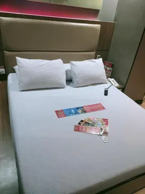 a bed with two pillows and two magazines on it at Hotel Sogo Edsa Taft in Manila
