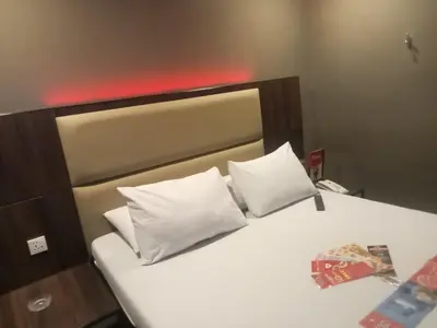 a bedroom with a bed with white pillows at Hotel Sogo Pasay Wood Street in Manila