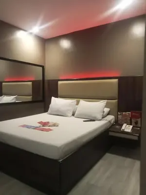 a bedroom with a large bed with white pillows at Hotel Sogo Pasay Wood Street in Manila
