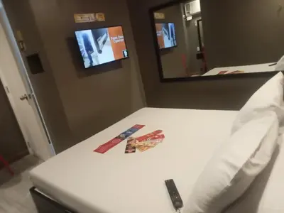 a bed with a remote control on it in a room at Hotel Sogo Pasay Wood Street in Manila