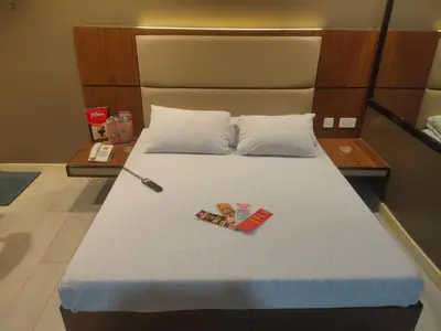 a bed with two pillows and a knife on it at Hotel Sogo Macapagal in Manila