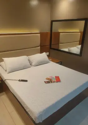 a large bed in a room with a mirror at Hotel Sogo Macapagal in Manila