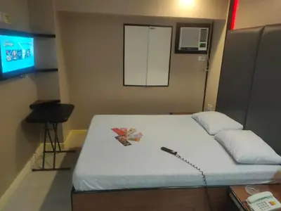 a room with a bed with a phone on it at Hotel Sogo Macapagal in Manila