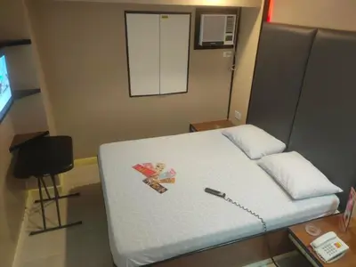 a room with a bed with a cell phone on it at Hotel Sogo Macapagal in Manila