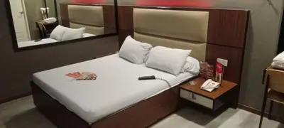 a small bed in a room with a mirror at Hotel Sogo Buendia in Manila