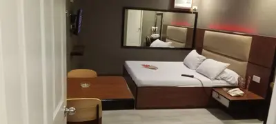 a small room with a bed and a mirror at Hotel Sogo Buendia in Manila