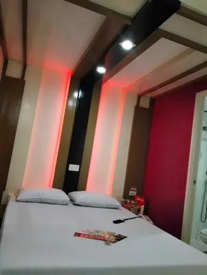 a bedroom with a bed with red and pink lights at Hotel Sogo Roxas Blvd in Manila