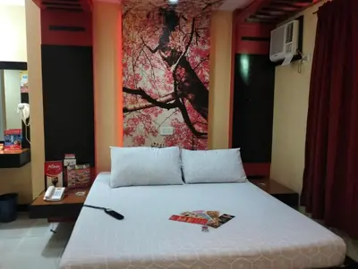 a bedroom with a bed with a painting on the wall at Hotel Sogo Roxas Blvd in Manila