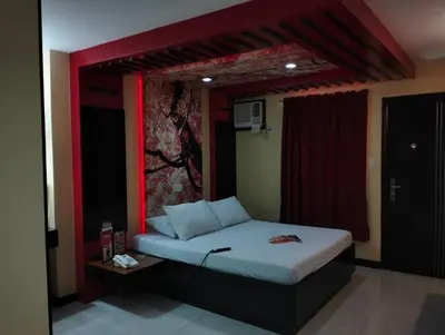 a bedroom with a bed with a red frame at Hotel Sogo Roxas Blvd in Manila