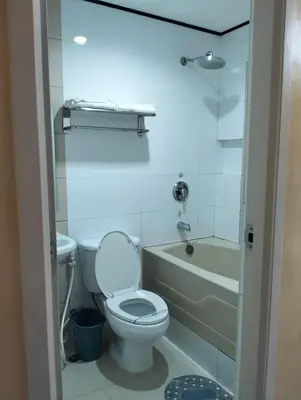 a bathroom with a toilet and a tub and a sink at Hotel Sogo Roxas Blvd in Manila