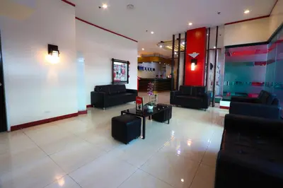 a lobby with couches and tables in a building at Hotel Sogo Yabut in Manila