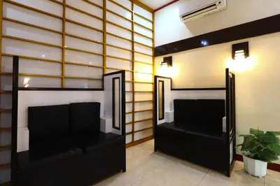 a room with two black leather couches and two mirrors at Hotel Sogo Yabut in Manila