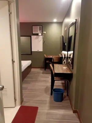a small room with a desk and a bedroom at Hotel Sogo General Trias in General Trias