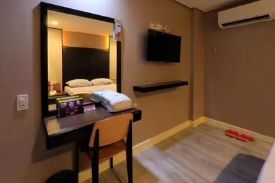 a room with a desk with a mirror and a bed at Hotel Sogo General Trias in General Trias
