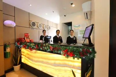 three men standing behind a counter with christmas decorations at Hotel Sogo General Trias in General Trias