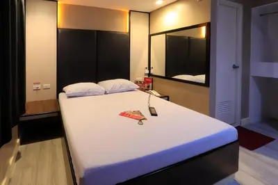 a bedroom with a large white bed with a mirror at Hotel Sogo General Trias in General Trias