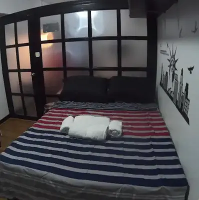 two towels on a bed in a room at Rsquared Condo in Manila