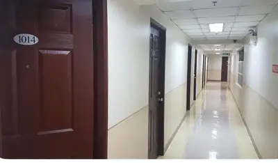 an empty hallway in a hospital with doors and a hallway at Rsquared Condo in Manila