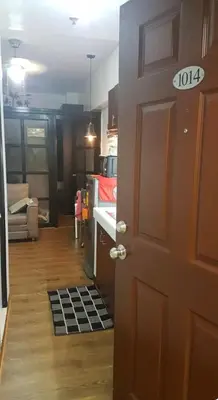 a room with a door and a kitchen with a stove at Rsquared Condo in Manila
