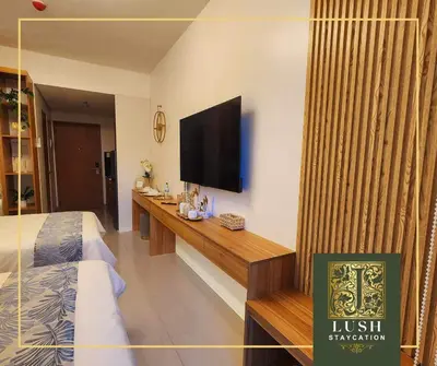 a hotel room with a bed and a flat screen tv at Modern Condo Near Ayala Avenue Makati City CBD at Lush Residences in Manila