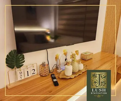 a shelf with a clock and a tv on top at Modern Condo Near Ayala Avenue Makati City CBD at Lush Residences in Manila