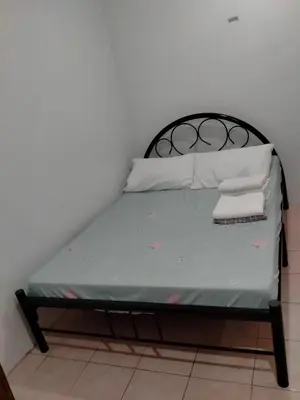 a bed with a black frame and white pillows on it at San Isidro Cabuyao TRANSIENT in Banlik