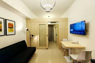 a living room with a couch and a table and a tv at 1BR Condotel with Balcony at SM Light Residences #LT05 in Manila