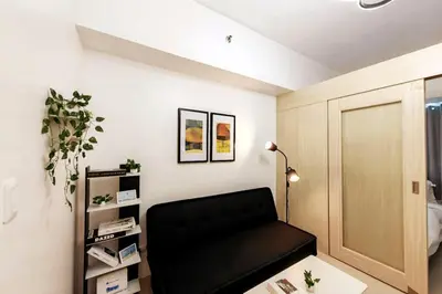 a living room with a black couch in a room at 1BR Condotel with Balcony at SM Light Residences #LT05 in Manila